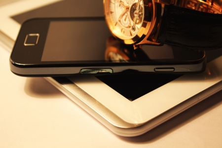 Golden wrist watch,smartphone and white tablet PCの写真素材