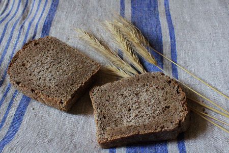 Two slices of rye homemade bread and rye spikeletsの写真素材