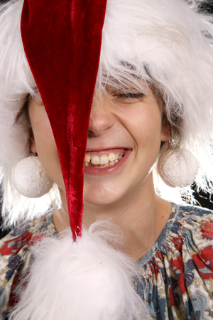 Young girl wearing a santa claus hat on a black backgroundの写真素材