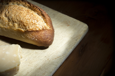 French bread and Parmesan cheese on a cheese board. Dark backgroundの写真素材