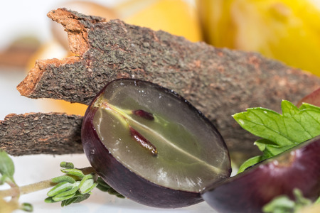 Bark of cinnamon with with half grape on white backgroundの写真素材