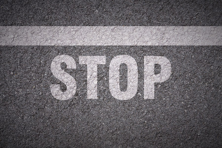 Stopping line and stop lettering on asphalt textureの写真素材