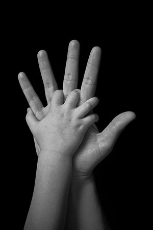 mother and child holding hands on black backgroundの写真素材