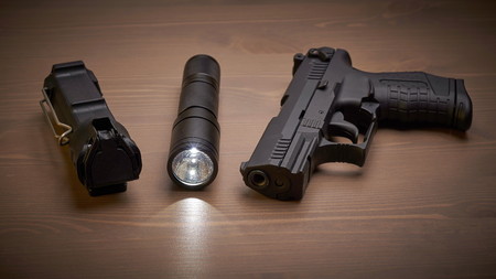 self defense gear - pistol, pepper and tactical flashlight on wooden surfaceの写真素材