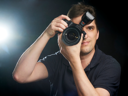 Male photographer taking a picture with a lightning in the backgroundの写真素材