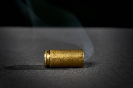 Smoking bullet casing dropped on the groundの写真素材