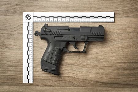 Crime Scene Investigation - handgun as a piece of evidence placed with forensic rulers for documentationの写真素材