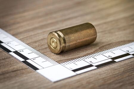 Crime Scene Investigation - bullet as a piece of evidence placed with forensic rulers for documentation - closeupの写真素材
