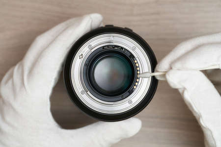 cleaning the electrical contacts of a modern lens using cottonの写真素材