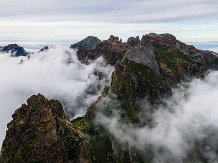 Breathtaking hiking trail with a view of a beautiful mountain landscape above the clouds of Madeira...