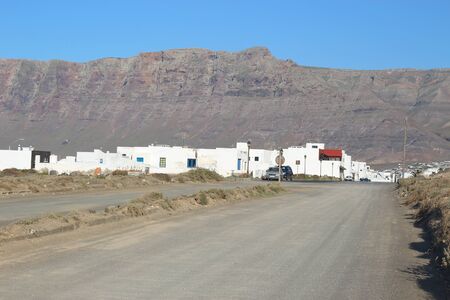 LANZAROTE, SPAIN - MARCH 15, 2016: The village Caleta de Famara against the background of the cliffs El Risco de Famara. Lanzarote, Canary Islands, Spain.のeditorial素材