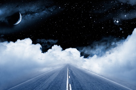 An empty road leading off into a surrealistic setting in outer space with stars and a crescent moon.の写真素材
