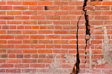 An old brick wall with major cracks and structural damage.の写真素材