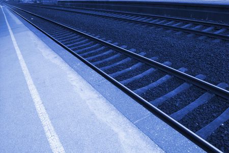 Railway lines at a train station disappearing into the distance.