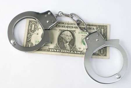 Close-up handcuffs and money over white background. Not isolated. 