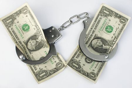 Close-up handcuffs and money over white background. Not isolated.の写真素材