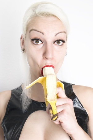 Beautiful sexy young woman eating banana. Not isolated.の写真素材