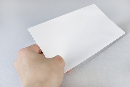 Female hand holding an envelope over white background. Not isolatedの写真素材