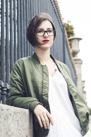 Street fashion concept. Portrait of elegant young beautiful woman. Paris buildings as background.の写真素材