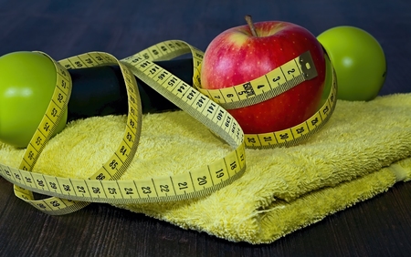 Red apple with measuring tape on a yellow towel.の写真素材