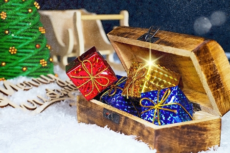 Snowflakes covered with evening sky with Santa Claus sleigh, Christmas tree and chest full of...