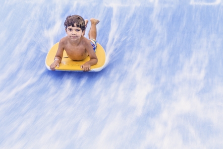 Small child riding a wave on a boogie board 