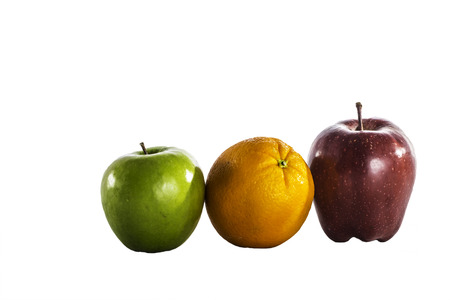 Juicy fresh apples and an orange isolated on a white .の写真素材