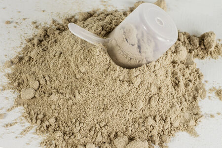A pile of chocolate protein powder with a scoop.の写真素材