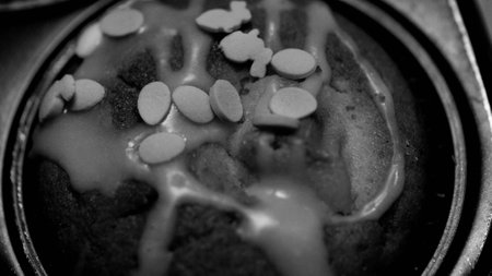 A black and white close-up of a delicious cupcake decorated with sugar sprinkles and frosting.の写真素材