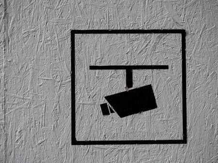 Close-up of a cctv camera sign painted on a white wall on a construction site.のeditorial素材