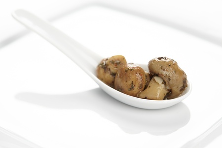 Pickled mushrooms on a porcelain spoon.の写真素材