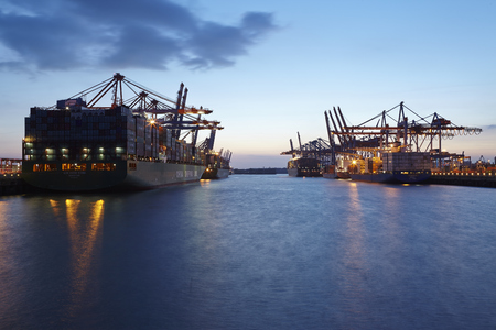 Container vessels XIN Hong Kong, Evridiki G and UMM Salal are loaded/unloaded at the terminal Burchardkai and Eurogate in the deepwater port Hamburg-Waltershof in the evening of May 2014, 15.のeditorial素材