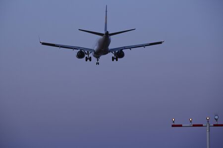 A passenger airplane is flying at the sky in the evening near Sunset Blvd