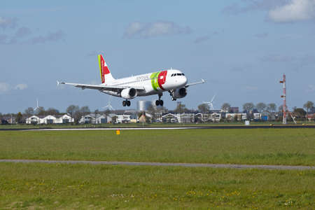 An Airbus A320-214 of TAP Portugal lands at Amsterdam Airport Schiphol (The Netherlands, AMS) on May 7, 2015. The name of the runway is Polderbaan.のeditorial素材