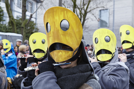 Some fully costumed carnival activists walk through the city during the carnival procession (cortege) of the Carnivel at Basel 2016 (Basle - Switzerland) on February 15, 2016. Some unidentified visitors watching the procession from the edge of the road.のeditorial素材