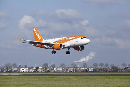 The Easyjet (Amsterdam livery) Airbus A319 with identification G-EZDN lands at Amsterdam Airport Schiphol (The Netherlands, AMS), Polderbaan on April 8, 2016.のeditorial素材