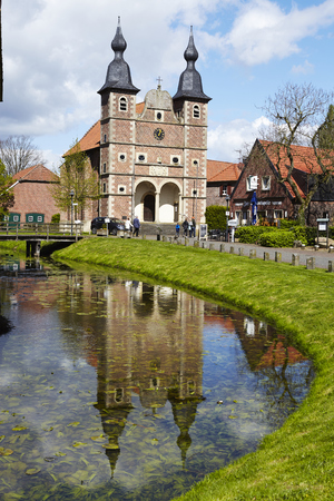 The castle chapel St. Sebastian reflects into the moat of castle Raesfeld (County Borken, Northrhine Westphalia, Germany) on April 2017, 17.のeditorial素材