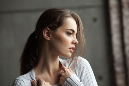 Close up portrait of attractive brunette woman in dark interiorの写真素材