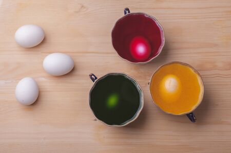 Eggs in colorful dyes prepare for easter holiday celebrationの写真素材