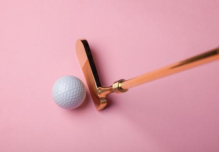 luxury golden golf club near golf ball on pink background