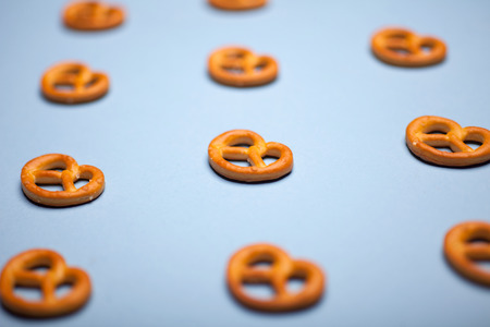 many PRETZELS on blue background, selective focus photoの写真素材