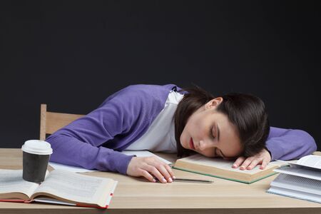 attractive student adult girl slipping on class desk on education books
