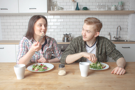 young lovely couple have fresh healthy breakfast on kitchen at home interior at morningの写真素材