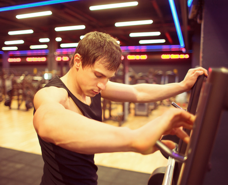sportsman after workout near barbell cage in gym