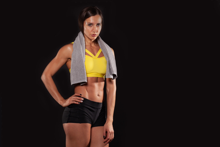 hispanic sportswoman with towel posing isolated on black backgroundの写真素材