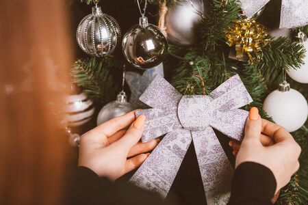 female hands decorating christmas tree with toysの写真素材