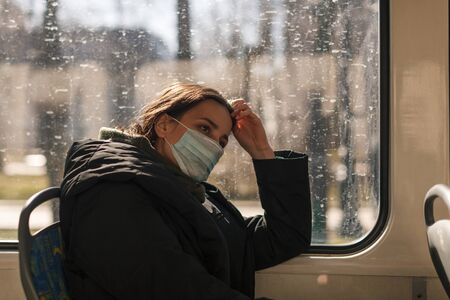 young european woman with medical mask in urban transport