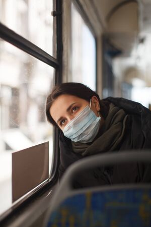 young european woman with medical mask in urban transportの写真素材
