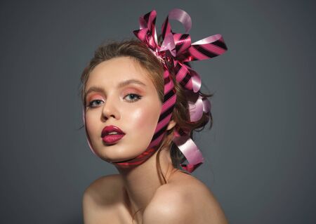 beauty young woman with gift ribbon on head, studio close up portraitの写真素材