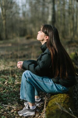 Young dreamy female alone in spring forest, wild natureの写真素材